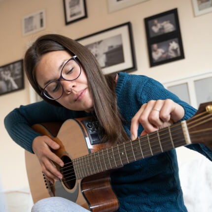 Nybegynner som utforsker strengene på en gitar.