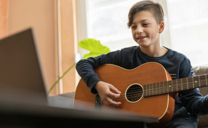 En ung gutt som spiller gitar.